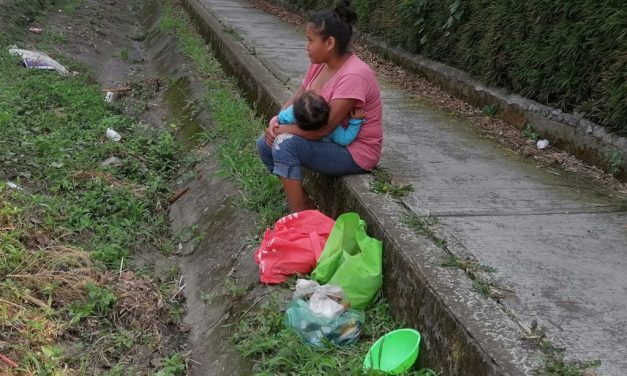 Camina horas sobre carretera en busca del sustento con su hija en brazos